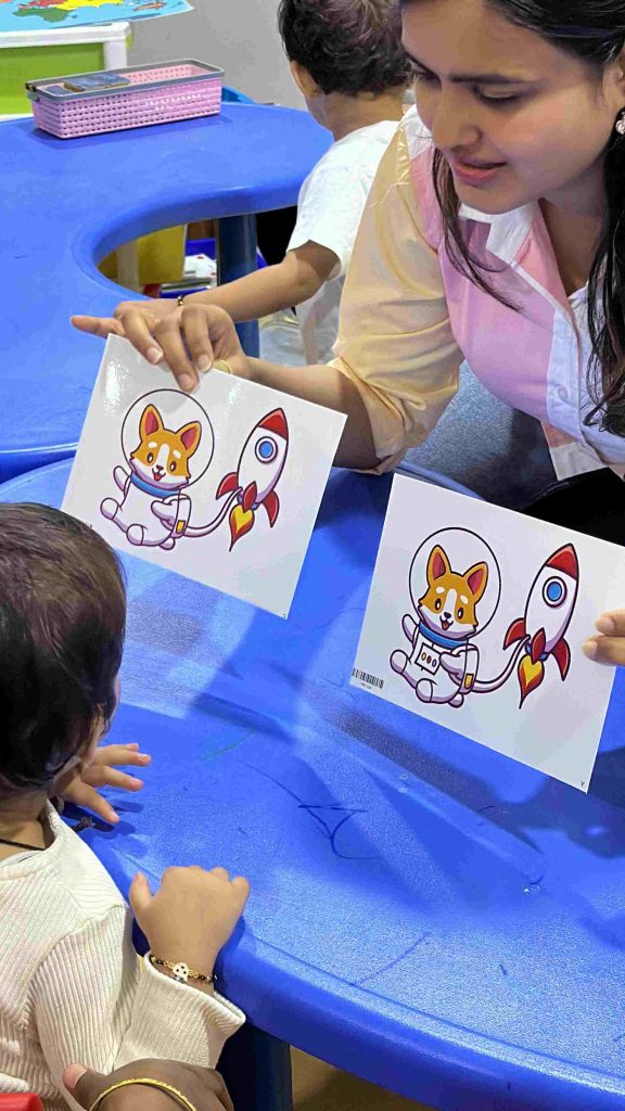 Toddlers engaged in an early learning flashcard activity with a teacher in brain development session
